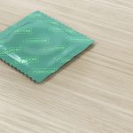 Condom on wood background