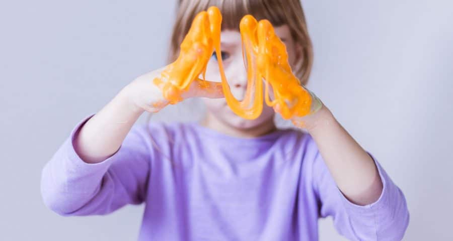 Little girl playing with orange slime