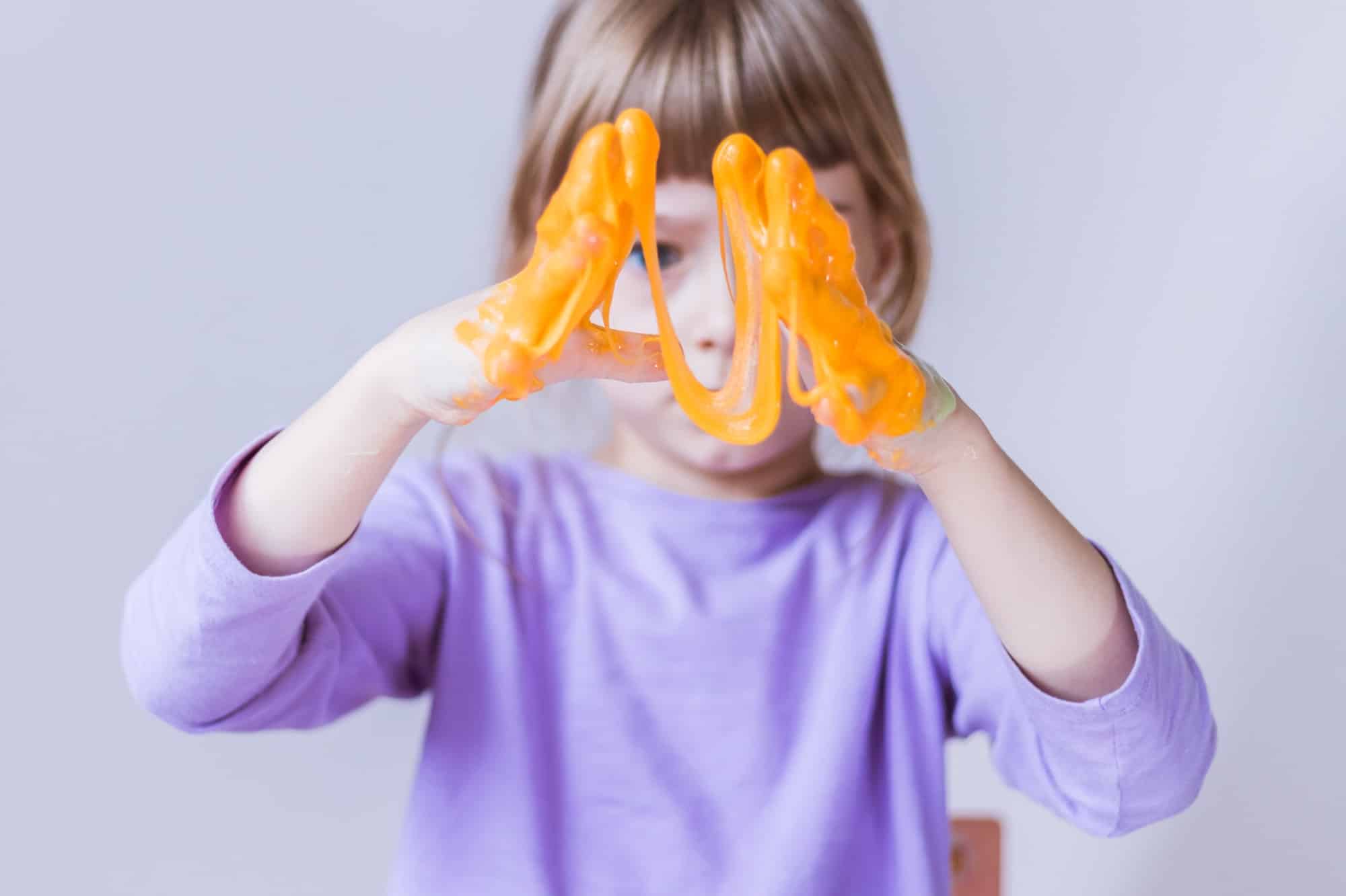 Little girl playing with orange slime